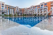 Открытый бассейн во внутреннем дворе апарт-отеля Premier Fort Beach в окружении жилых корпусов.