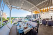 Открытая терраса ресторана со столиками и видом на море в апарт-отеле Premier Fort Beach, Святой Влас.