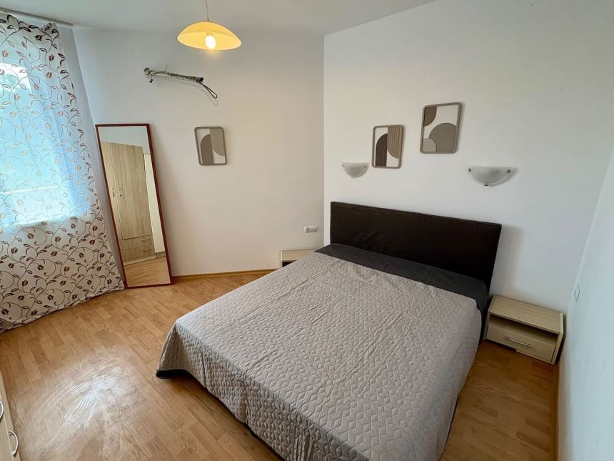Спальная зона студии 52 м² с двуспальной кроватью, прикроватными тумбами и зеркалом в ЖК Villa Aria