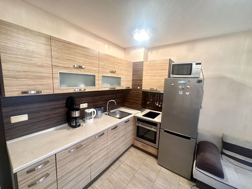 Кухонная зона со встроенным гарнитуром, плитой, духовым шкафом и холодильником. d3ob-63