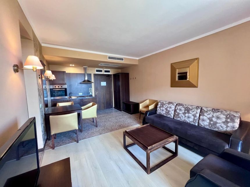 Общий вид гостиной с диваном, обеденной зоной и встроенной кухней в Barcelo Royal Beach